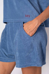Close-up of a blue cotton set with custom initials 'MS', showcasing pockets and soft fabric for comfort.