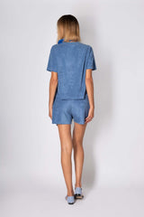 Rear view of a woman in a blue cotton set, featuring a relaxed top and shorts, perfect for summer comfort and style.