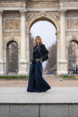 Model showcasing wide-leg Patagonna cotton pants and stylish jacket in front of a historic archway.