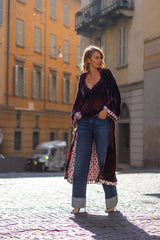 Model wearing the TOP PIZZO VELLUTO velvet top with jeans in a stylish urban setting.