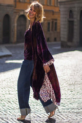 Model wearing a luxurious gradient velvet kimono with printed lining, paired with high-waisted jeans and stylish heels.