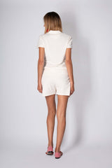 Woman wearing a light cotton polo set, showcasing the back view with a stylish and comfortable design.