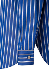 Close-up of a blue striped shirt sleeve featuring a button cuff design, showcasing a minimal chic style.