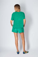 Stylish woman wearing a green cotton set, featuring a relaxed t-shirt and shorts, perfect for summer comfort.