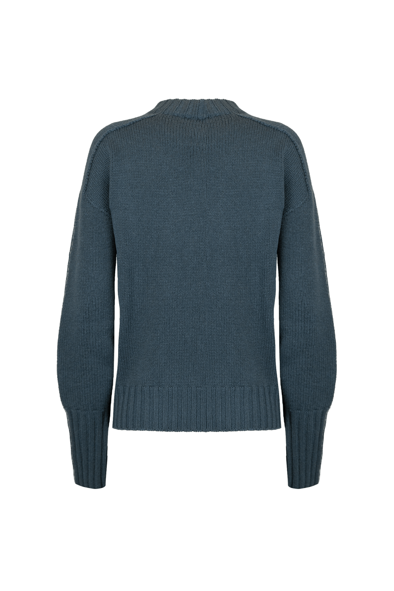 Back view of a loose-fitting cashmere crewneck sweater in deep teal color with ribbed hem.